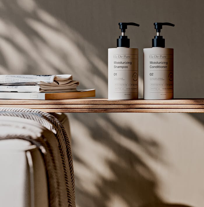 Elegant display of Ela De Pure moisturizing shampoo and conditioner on a wooden shelf with soft lighting.