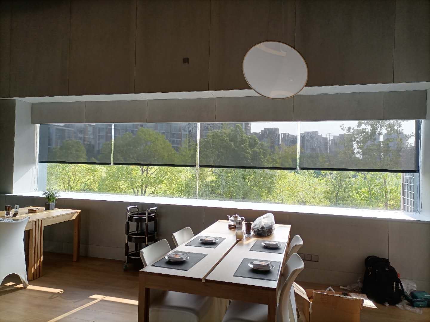Large window light filtering roller blinds in a commercial-style interior