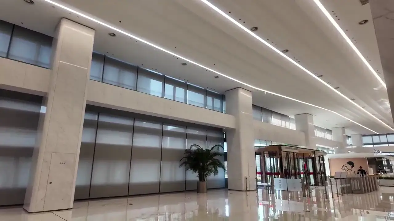 JD.com Headquarters Motorized Shading Project — Beijing Yizhuang Large glazed public interior with multiple installed roller shades.
