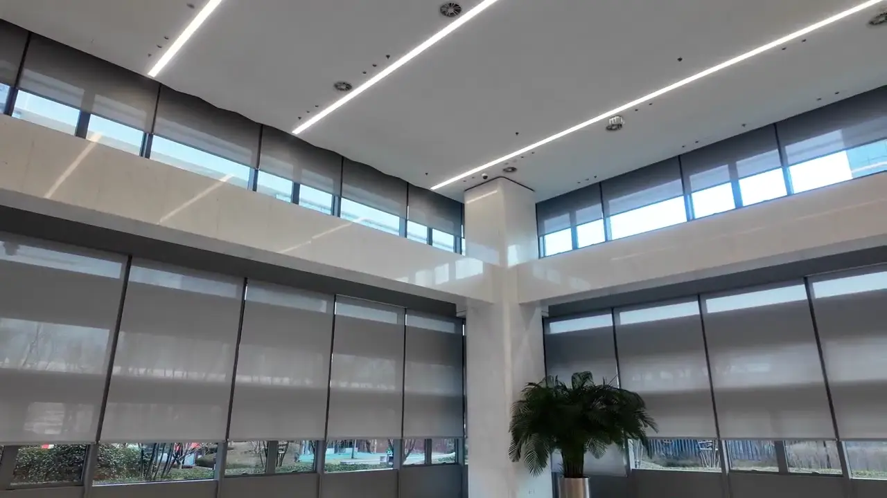 JD.com Headquarters Motorized Shading Project — Beijing Yizhuang Partially lowered roller shades across a large curtain-wall area.